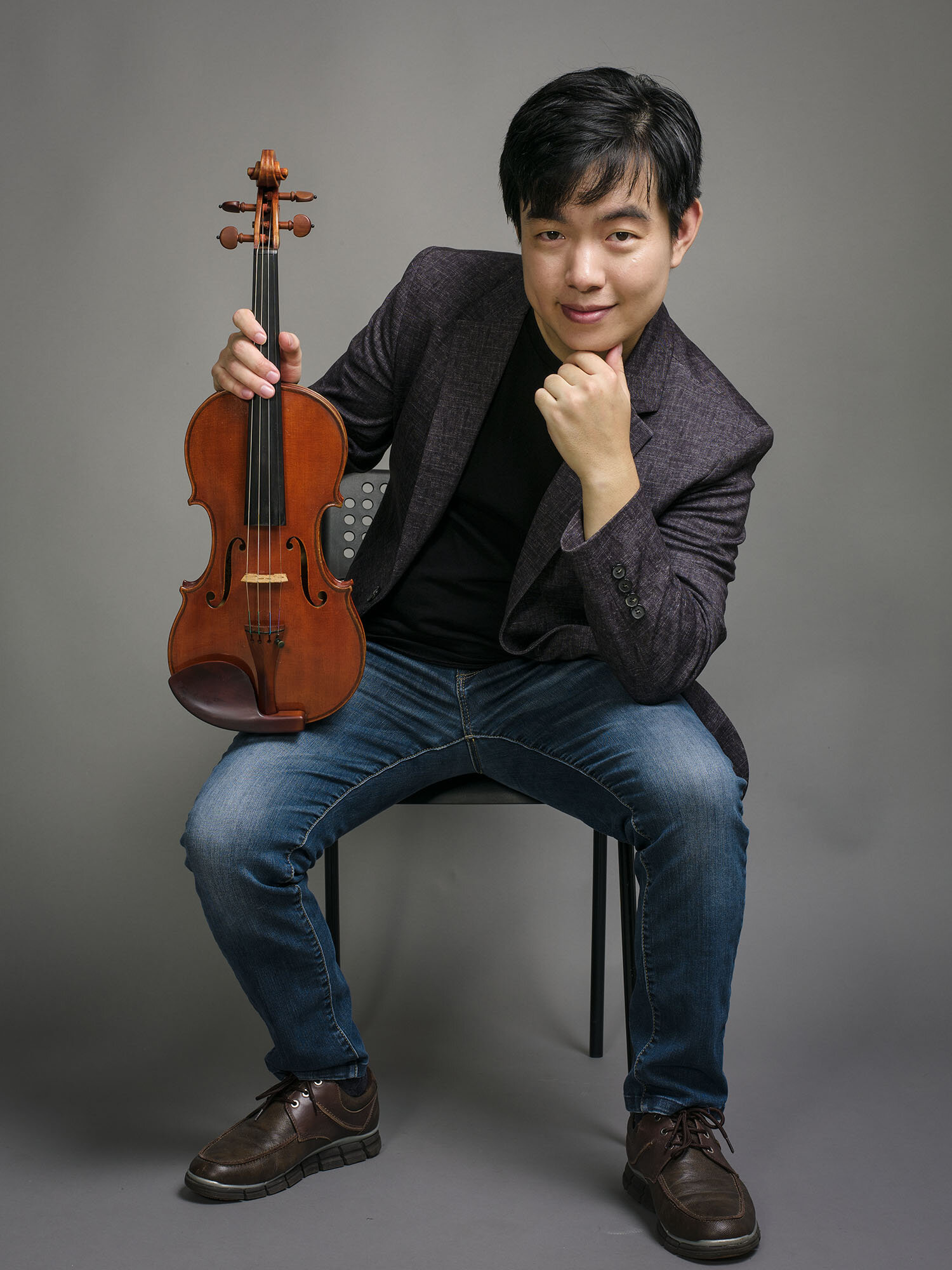 Brian Bak seated with his violin